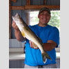 Guy in blue shirt holding fish